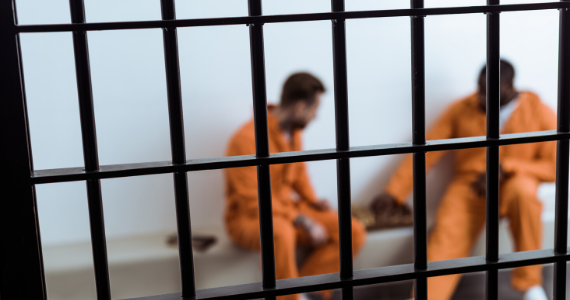Two inmates sit in jail cell
